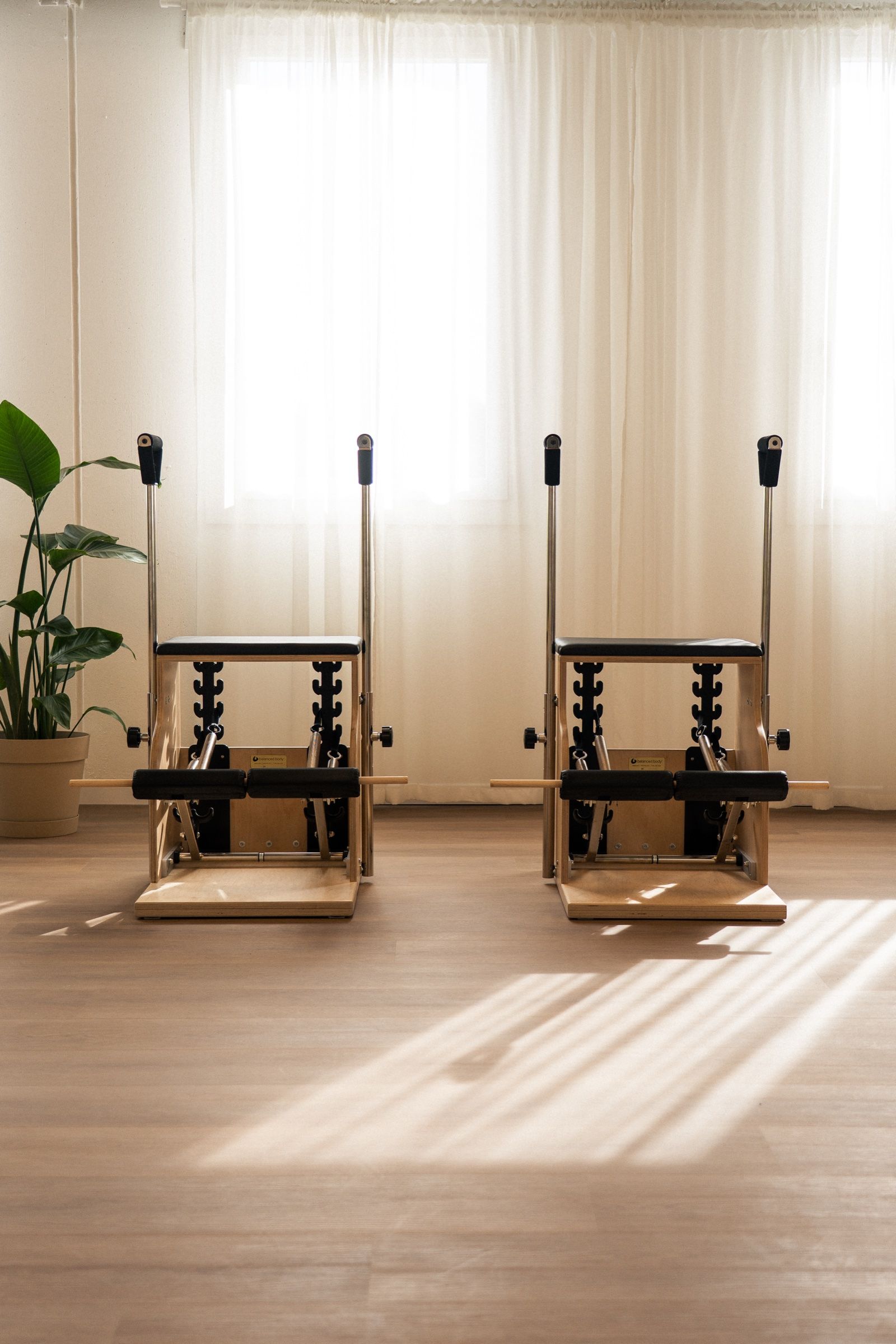 Due Chair in legno davanti alle tende illuminate dal sole